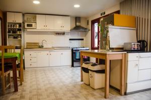 a kitchen with white cabinets and a table at El Patagónico Hostel in Puerto Natales