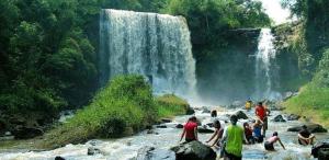 un grupo de personas de pie en un río con una cascada en CASA DE CAMPO PATRIMÔNIO en Brotas