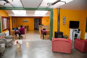 a living room with a person sitting at a table and a fireplace at El Patagónico Hostel in Puerto Natales