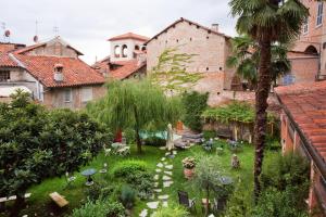 einen Innenhof in einem alten Gebäude mit einer Palme in der Unterkunft Lori's Inn in Mondovì