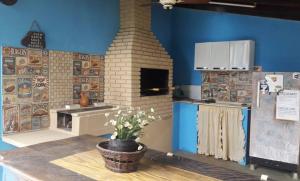 a kitchen with a brick oven in a blue wall at CASA DE CAMPO PATRIMÔNIO in Brotas
