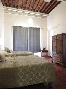 1 dormitorio con 2 camas, vestidor y ventana en El Viejo Zaguan by Lunian en Guanajuato