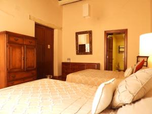 1 dormitorio con 2 camas, tocador y espejo en El Viejo Zaguan by Lunian en Guanajuato