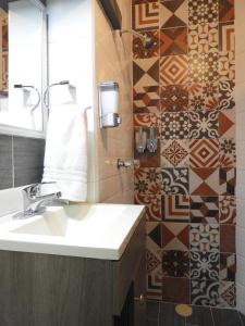 a bathroom with a sink and a tiled wall at Casa Estudio Frida y Diego Rivera by Lunian in Guanajuato