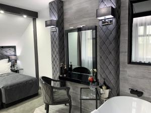 uma casa de banho com uma banheira, uma cama e um espelho. em Hotel Fado em Gorzów Wielkopolski