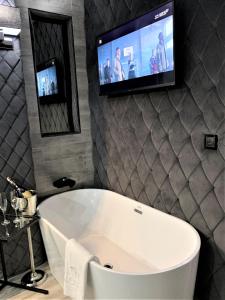 a bath tub sitting next to a television in a room at Hotel Fado OZONOWANY in Gorzów Wielkopolski