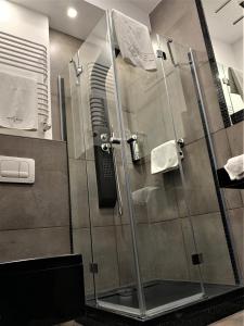 La salle de bains est pourvue d'une douche avec une porte en verre. dans l'établissement Hotel Fado, à Gorzów Wielkopolski