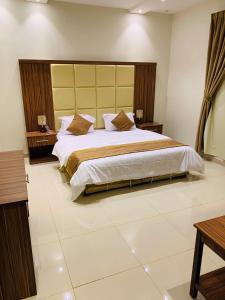 a bedroom with a large bed in a room at Al Bateel Furnished Apartments in Riyadh