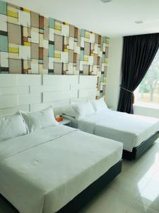 a hotel room with two beds and a window at GOODY HOTEL in Johor Bahru