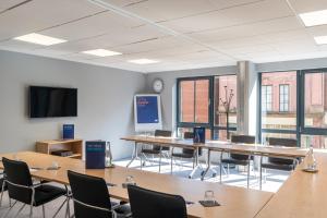 a conference room with tables and chairs and a tv at Holiday Inn Express - Derry - Londonderry by IHG in Derry Londonderry