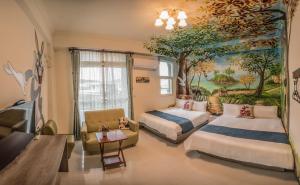 a bedroom with two beds and a painting on the wall at Rabbit Forest B&B in Ruisui