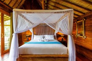 a bedroom with a bed with a canopy at Bali Natha Beach Front in Canggu