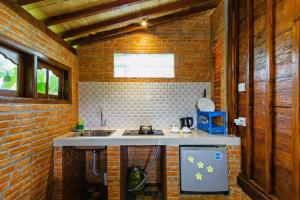 a kitchen with a sink and a brick wall at Bali Natha Beach Front in Canggu