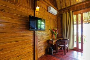 a living room with a television on a wooden wall at Bali Natha Beach Front in Canggu