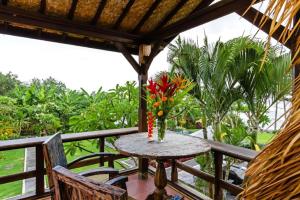 a table with a vase of flowers on a balcony at Bali Natha Beach Front in Canggu
