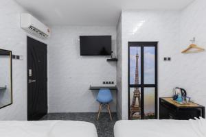 Habitación con cama y TV en la pared. en Lee Luxury Home en Gelugor