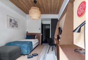 a bedroom with a bed and a couch and a chair at EARTHMANS OSAKA-JO in Osaka