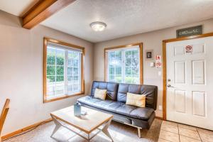 a living room with a leather couch and a table at Beaches Inn | Sandpiper Pier Cottage in Cannon Beach