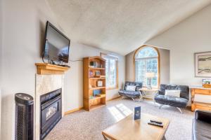 sala de estar con chimenea y TV de pantalla plana en Beaches Inn | Pelicans View Cottage en Cannon Beach