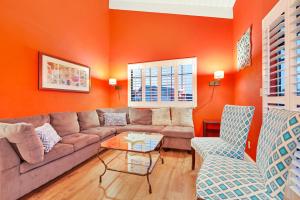 a living room with orange walls and a couch and chairs at Boardwalk Dream in Santa Cruz