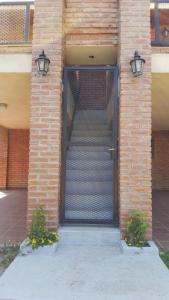 a front door of a brick building with two lights at Mardi - Departamentos de alquiler temporario in Bialet Massé