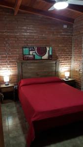 a bedroom with a red bed with two tables and two lamps at Mardi - Departamentos de alquiler temporario in Bialet Massé