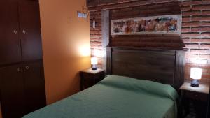 a bedroom with a bed and a brick wall at Mardi - Departamentos de alquiler temporario in Bialet Massé