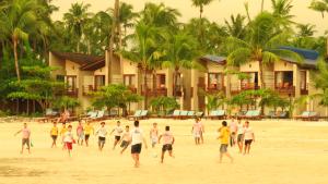 een groep mensen die voetballen op het strand bij Pleasant View Resort in Ngapali