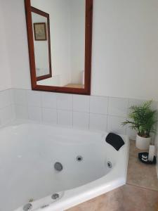 a white bath tub in a bathroom with a mirror at Chateau Bass in Bass +37 photos