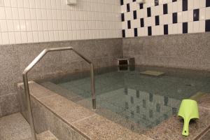 a bath tub with a glass floor in a bathroom at Hotel Hokke Club Sapporo in Sapporo