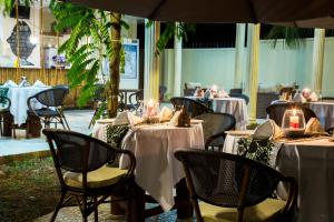 un restaurante con mesas y sillas con mantel blanco en Antonio Garden Hotel en Zanzíbar