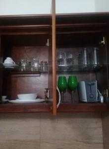 un armario de cristal con platos y platos. en Spencer Holiday Apartments/Seagull complex en Nuwara Eliya