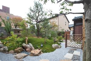 un jardin avec des rochers et une clôture dans l'établissement Musashi Sakaean, à Kanazawa