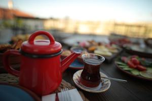 Prime Cappadocia Suites في نوشهر: طاولة مع غلاية الشاي الأحمر وأطباق الطعام