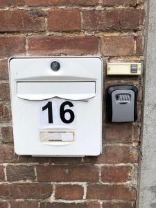 une boîte aux lettres blanche sur le côté d'un mur de briques dans l'établissement Studio Samson, à Vernon