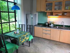 a kitchen with a table and a refrigerator at Lanta Complex in Ko Lanta