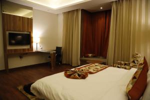 Ένα ή περισσότερα κρεβάτια σε δωμάτιο στο Lotus Ananta Elite Kota