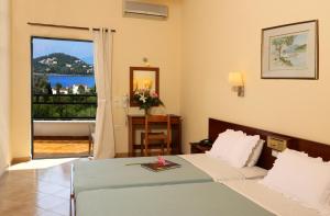um quarto com uma cama e vista para uma varanda em Paradise Hotel Corfu em Gouviá mais 37 fotografias
