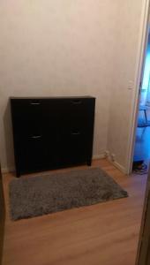 a black dresser in a room with a rug at Studio lumineux et confortable in Chaumont