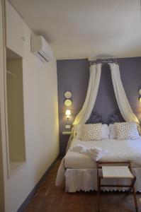 a bedroom with a bed with a purple wall at Il Nido Di Anna in San Gimignano