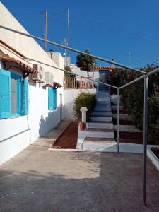a stairway leading up to a building with blue shutters at Beautiful Island house with sea view in Spiliazéza +30 photos
