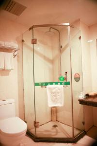 uma casa de banho com um chuveiro, um WC e uma toalha em GreenTree Inn Puyang Fan County People Avenue Banqiao Road Hotel em Yancunpu