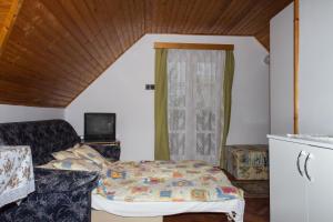 バラトンフェニヴェシュにあるFamilia Nyaraló 87のベッドルーム(ベッド1台、ソファ、テレビ付)