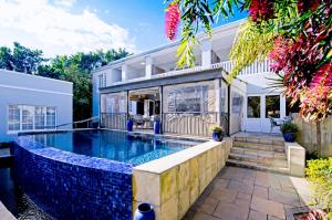 a swimming pool in the backyard of a house at Lodge on Main Guest House and Conference Centre in Port Elizabeth