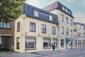 two people walking in front of a building at Hotel Riche in Valkenburg