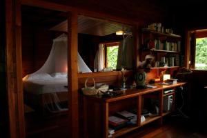 a bedroom with a bed and a desk with a desk at La Ceiba Reserva Natural in Puerto Viejo