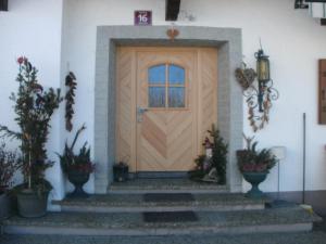 a wooden door on a house with potted plants at Viehhofbauer in Maria Alm am Steinernen Meer
