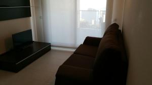 Una sala de estar con un sofá y un televisor. en Apartamento con fantásticas vistas al mar, en Benidorm