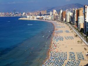 Une plage avec beaucoup de gens et l'océan dans l'établissement Apartamento con fantásticas vistas al mar, à Benidorm