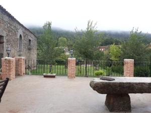 a patio with a fence and a stone bench at Casa La Almazara in La Parra